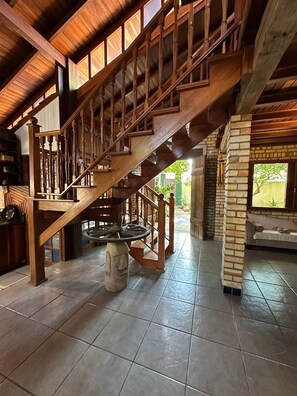 A wooden staircase with a handrail, leading to an upper level.