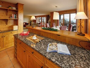 Eine Küche mit Granit Arbeitsplatten, Holzschränken und einem Essbereich mit Blick.