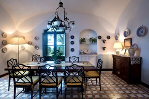 Ein Esszimmer mit Tisch, Stühlen und einer Pendelleuchte.