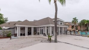 Un grand bâtiment à deux étages, doté d’un patio couvert et d’une piscine.