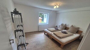 A bedroom with two beds, a window, a radiator, and a ceiling light fixture. - Apartment 'Fewo Am Adlerweiher' with Shared Terrace, Shared Garden and Wi-Fi (Feldberg (Schwarzwald))