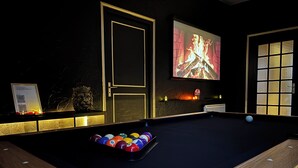 A billiards table with balls, a fireplace, and a projection screen displaying a fire. - The secret lodge (Dolus-le-Sec)