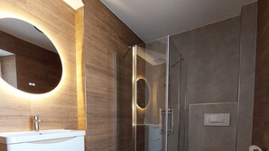 A modern bathroom with a glass-enclosed shower, a round mirror, and a toilet. - Comfort Breakfast Room with Balcony and Moselle View for 2 in Ediger-Eller (20 m²) (Ediger-Eller)