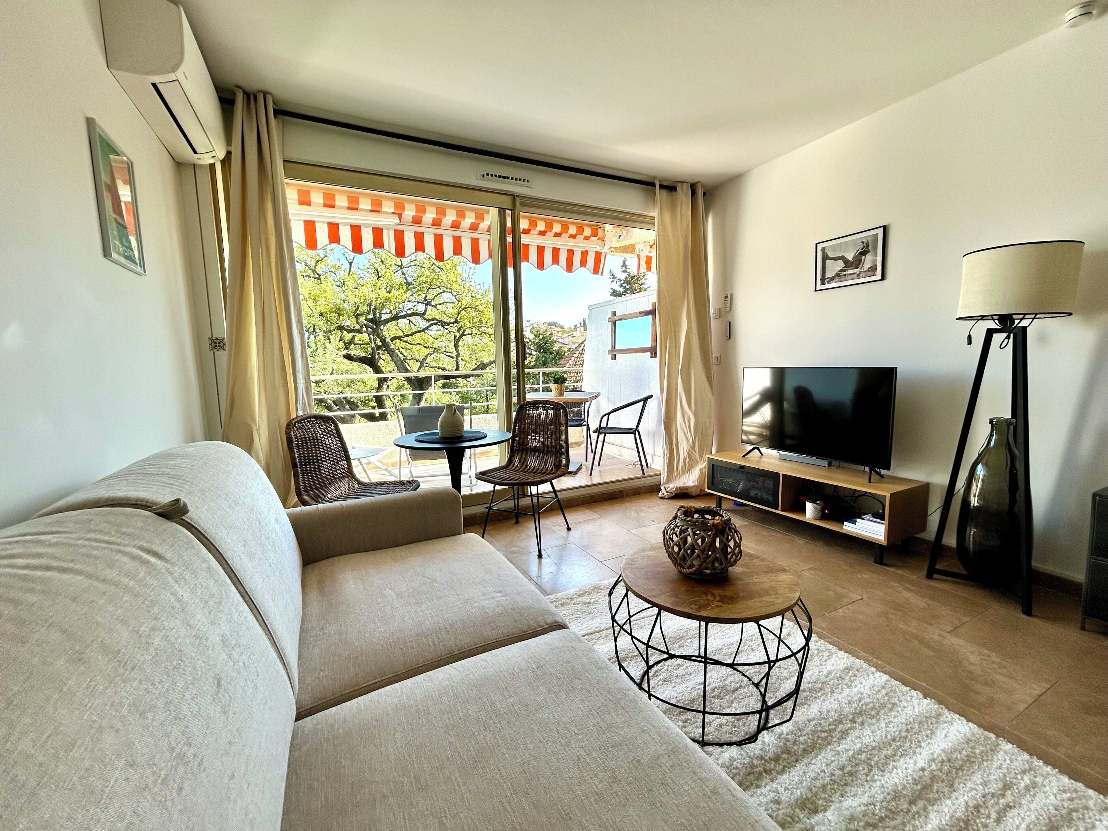 Un soggiorno con divano, televisione e zona pranzo con sedie e tavolo.
