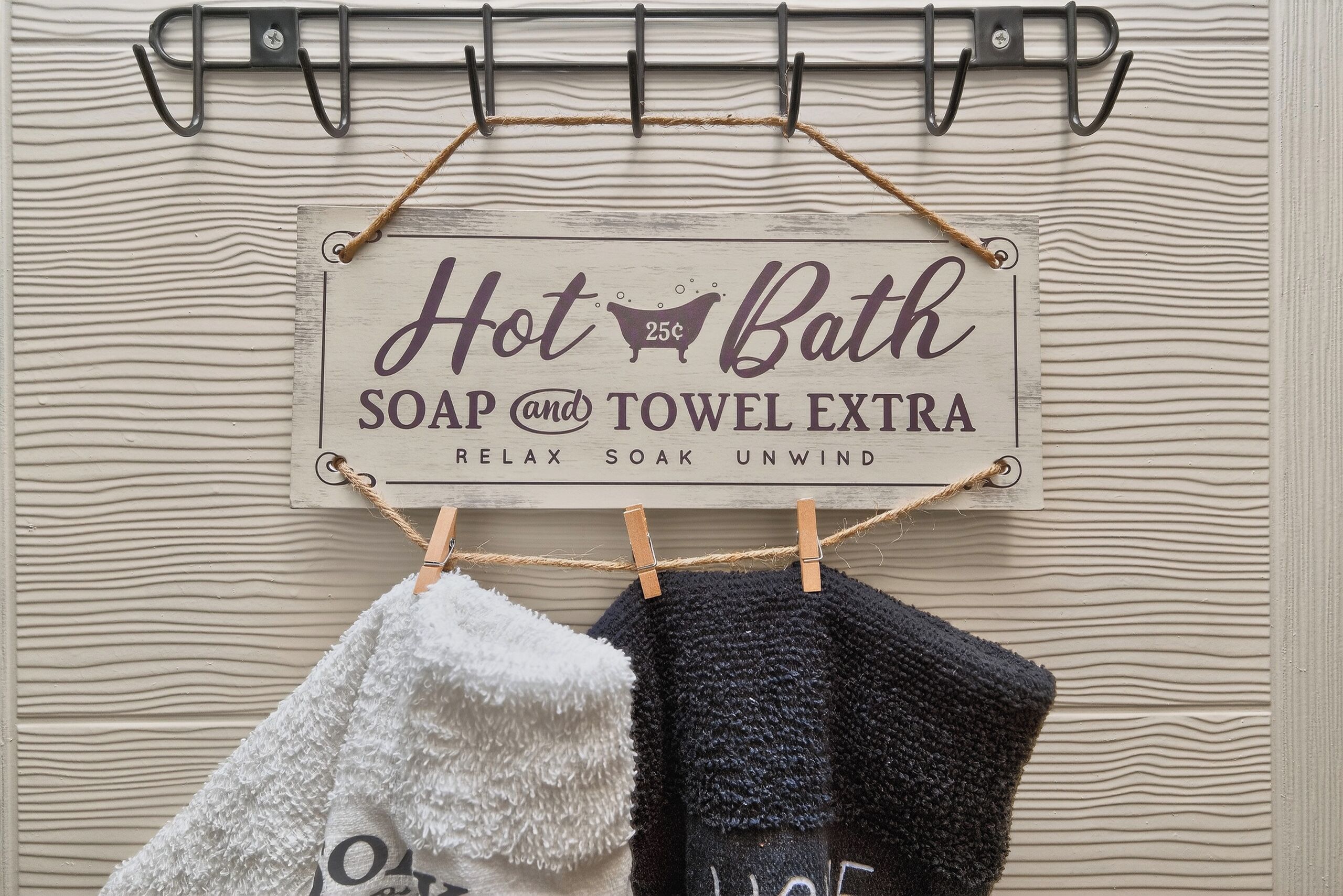 A sign for a bath and towel service, with a rack of towels.
