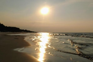 A beach with the sun low on the horizon, reflecting on the water. - Large, Comfortable Holiday Home With a Garden (Smoldzino)