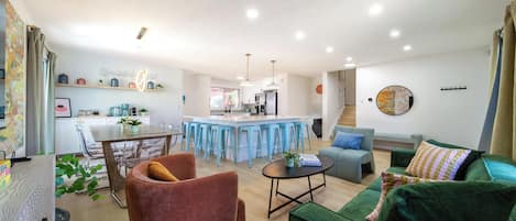 A modern living space with a kitchen, dining area, and seating area.