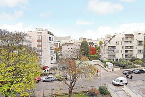A residential area with multi-story apartment buildings, a parking lot with cars, and trees with autumn foliage. - Charming Studio 2P - Courbevoie (Courbevoie)