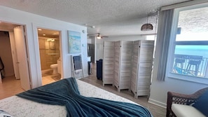 Ein Schlafzimmer mit Bett, begehbarem Kleiderschrank, Bad und Meerblick.