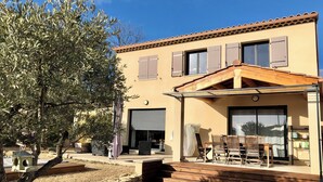 A two-story house with a patio, outdoor furniture, and a stone wall. - House with swimming-pool in Luberon (Lauris)