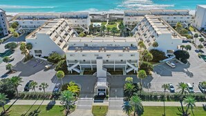 A modern hotel with a central courtyard, multiple floors, and a view of the ocean. - 🏖️Stunning Gulf Views | Pool | Aegean 220🏖️ (Destin)