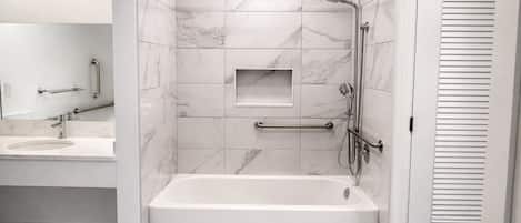 Un baño moderno con bañera, ducha y tocador con lavamanos.