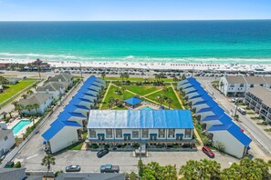 Ein Hotel mit blauem Dach, Schwimmbad und Blick auf den Strand.