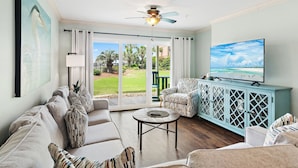 A living room with a sofa, armchairs, a coffee table, a TV, and a view of the outdoors. - 🏖️Steps to Beach | Pet Friendly | Pool | Ciboney 1001🏖️ (Miramar Beach)