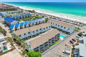 Ein Hotel mit mehreren Etagen, einem Pool und Blick auf den Strand.