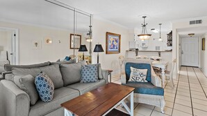 Ein Wohnzimmer mit einer Couch, einem Couchtisch und einem Essbereich mit Stühlen und einem Tisch.