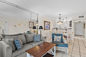 Ein Wohnzimmer mit einer Couch, einem Couchtisch und einem Essbereich mit StĂŒhlen und einem Tisch.
