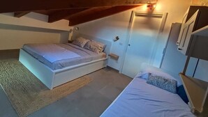 A bedroom with a bed, a bedside table, a door, and a wardrobe. - Thumbelina House (Sapri)