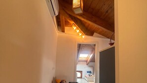 A narrow hallway with a ceiling fan, a chair, and a small table. - Thumbelina House (Sapri)