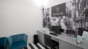 A modern office space with a desk, computer, and two chairs. A large poster with a cityscape and text is on the wall. - Suite Pulcinella (Naples)