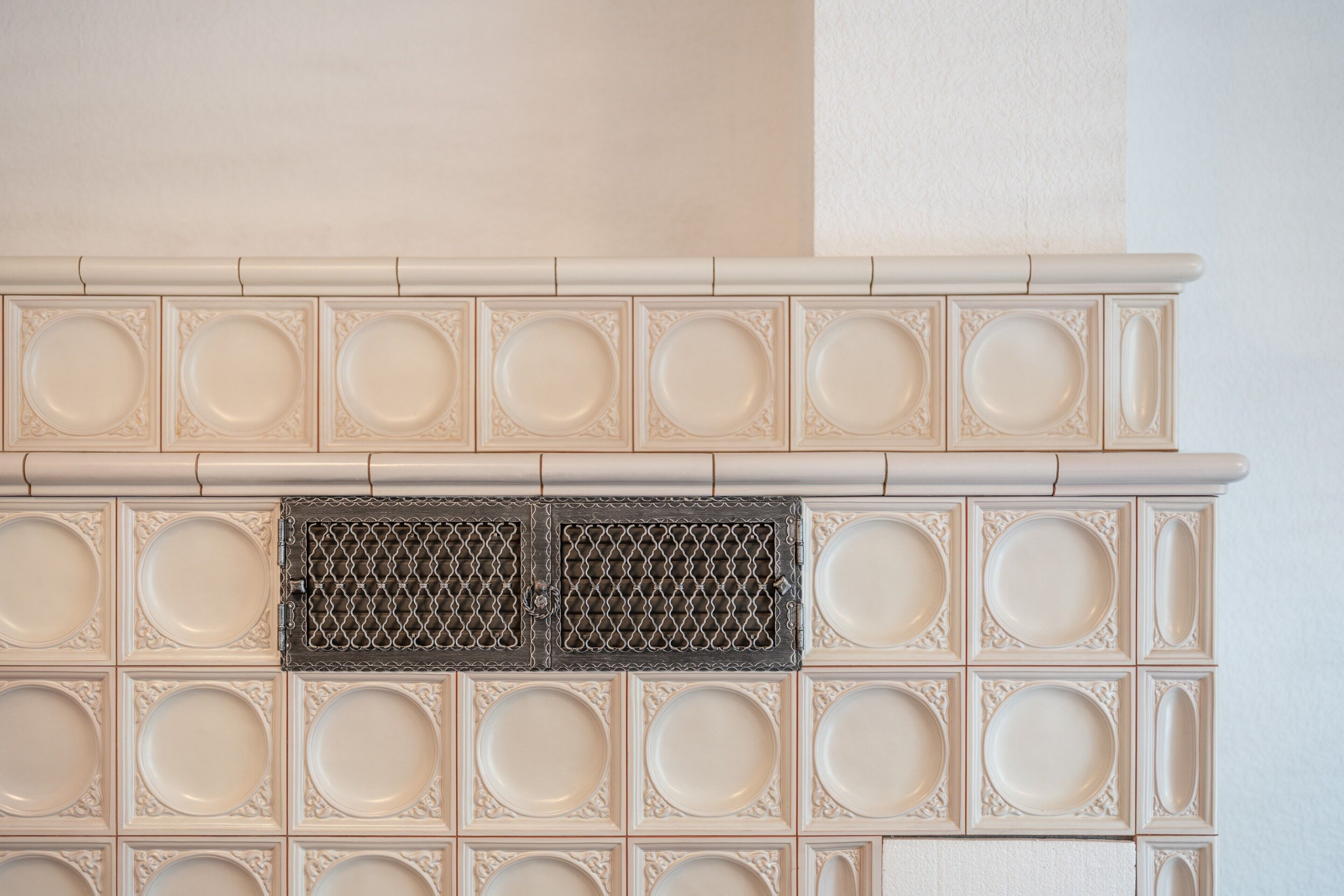 A fireplace with decorative panels and a central vent.