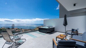 A balcony with a hot tub, seating area, and a view of the sea. - Daysy House by LovelyStay - Jacuzzi c/vista mar (Funchal)