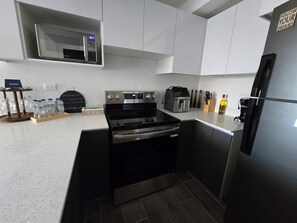 Una cocina moderna con horno empotrado, microondas y refrigerador.