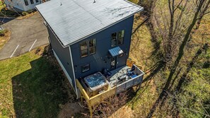 Ein zweistöckiges Haus mit Balkon, Whirlpool und Terrasse.