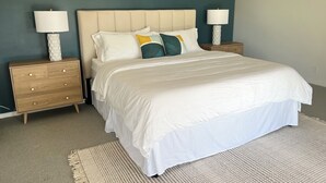 Ein Schlafzimmer mit einem Bett, zwei Nachttischen und zwei Lampen.