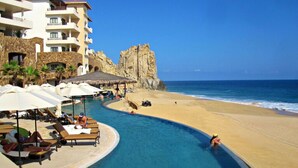 A resort with a pool, beach, and a rocky cliff. - Spacious 2 BR, 3 bath Presidential Suite. Pacific Ocean View. 6 guests welcome! (Cabo San Lucas)