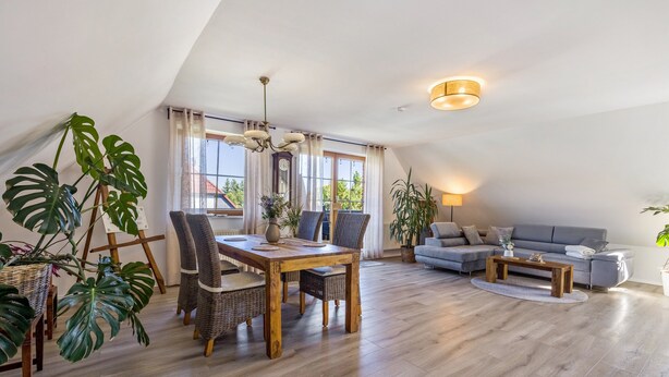 Un loft spacieux comprenant un coin repas, un canapé et de grandes fenêtres.