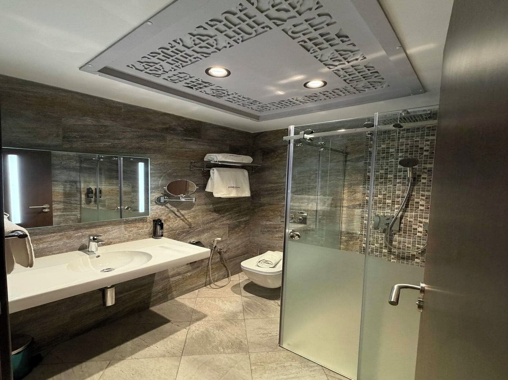 Shower, pengering rambut, kloset, dan handuk
