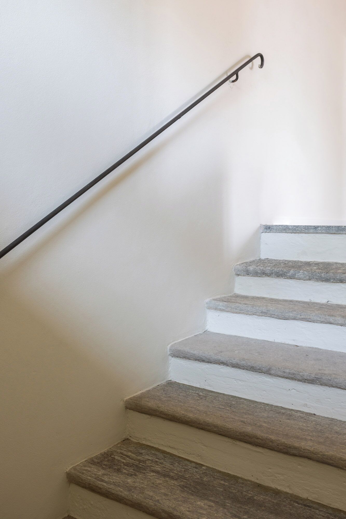 A staircase with a metal handrail and stone steps.