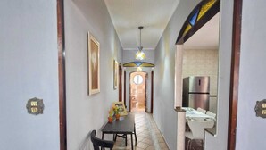 A hallway with a dining area, a kitchen, and a bathroom visible in the background. - House with pool in Praia Grande with 2 Wi-Fi networks in the house, comfortably accommodates up to 20 people!! (Praia Grande)