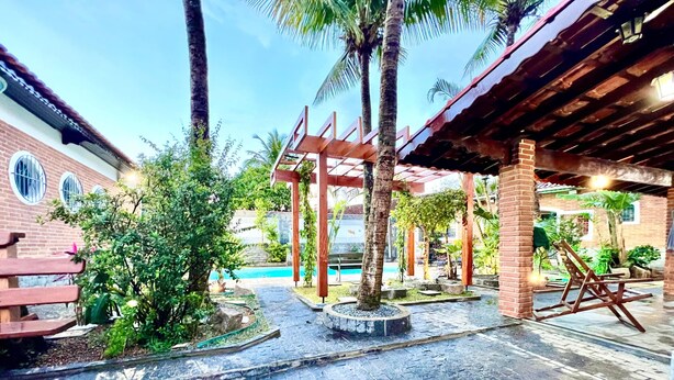 A courtyard with a pool, palm trees, and a wooden pergola. - House with pool in Praia Grande with 2 Wi-Fi networks in the house, comfortably accommodates up to 20 people!! (Praia Grande)