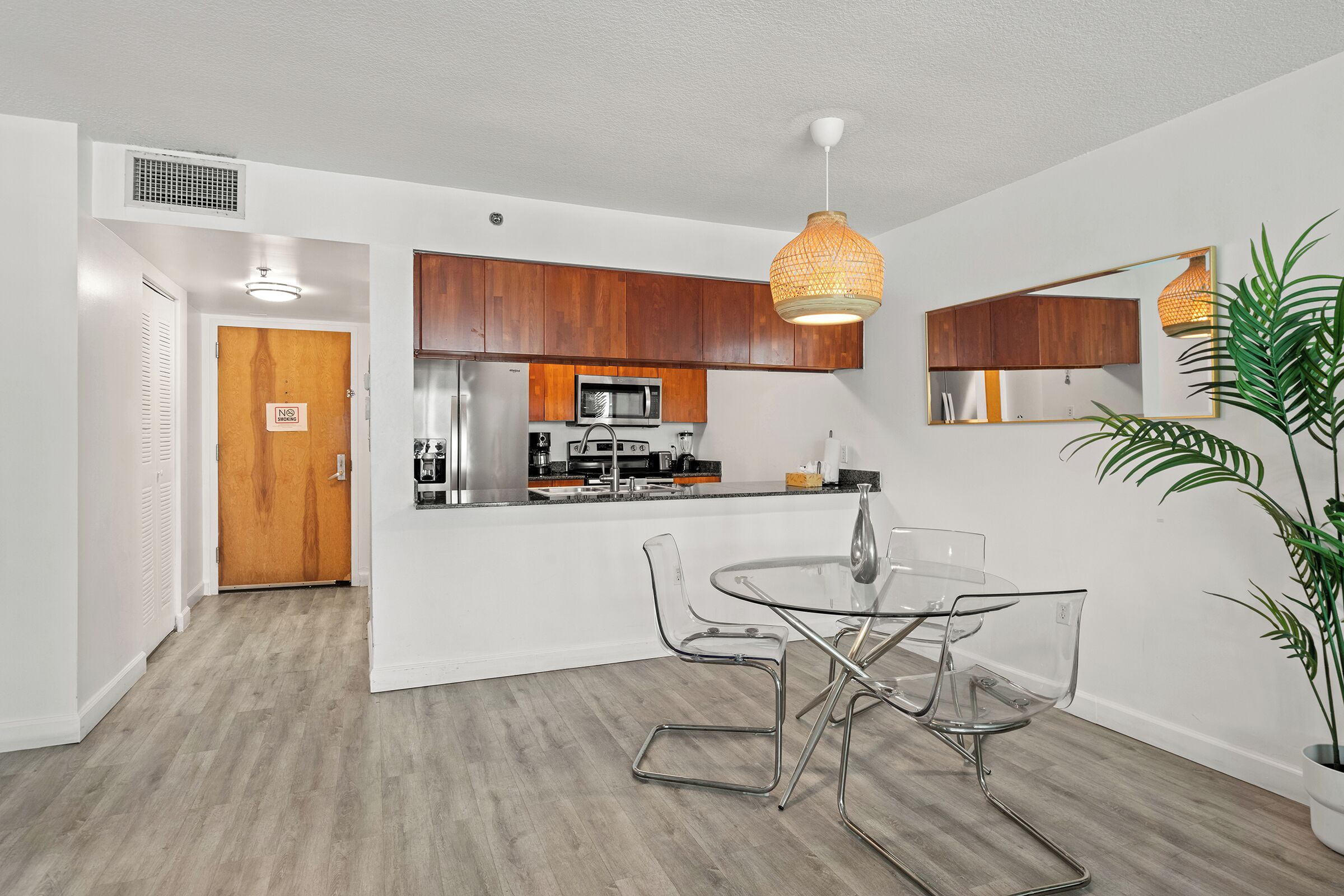 Eine moderne Küche mit Holzschränken, einem Edelstahlkühlschrank und einer Mikrowelle.