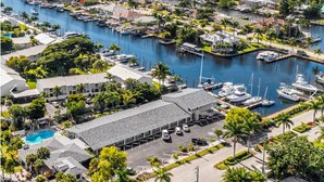 A marina with boats docked, a swimming pool, and a building with a parking lot. - Cozy 2 Queen Bed Studio in Sunny Fort Myers Beach (Fort Myers Beach)