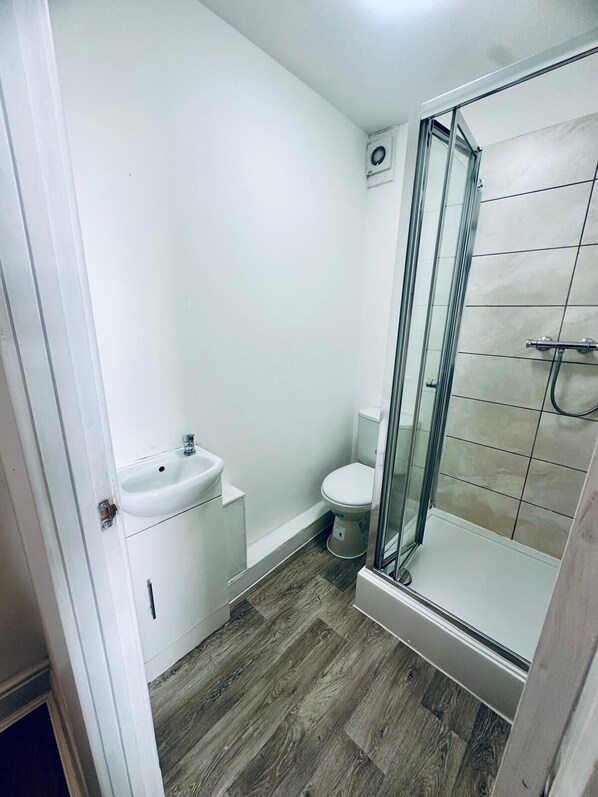 Un baño pequeño con lavabo, inodoro y cabina de ducha de vidrio.