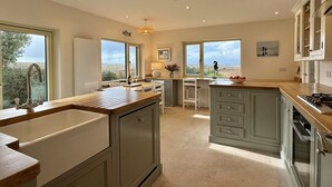 A spacious kitchen with a large island, ample natural light, and a view of the landscape. - Cottage 498 - Cleggan - sleeps 9 guests  in 4 bedrooms (Cleggan)
