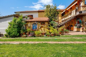 Ein Gebäude mit Balkon, Wandgemälde und Garten.