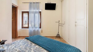 A bedroom with a bed, a TV, a wardrobe, and a window with curtains. - Room 'Stanza 1' with Mountain View, Wi-Fi and Air Conditioning (Casano)