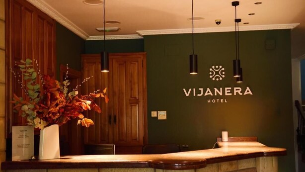 Una taquilla de fusta, una planta en test i un rètol que anuncia l'Hotel Vijanera.