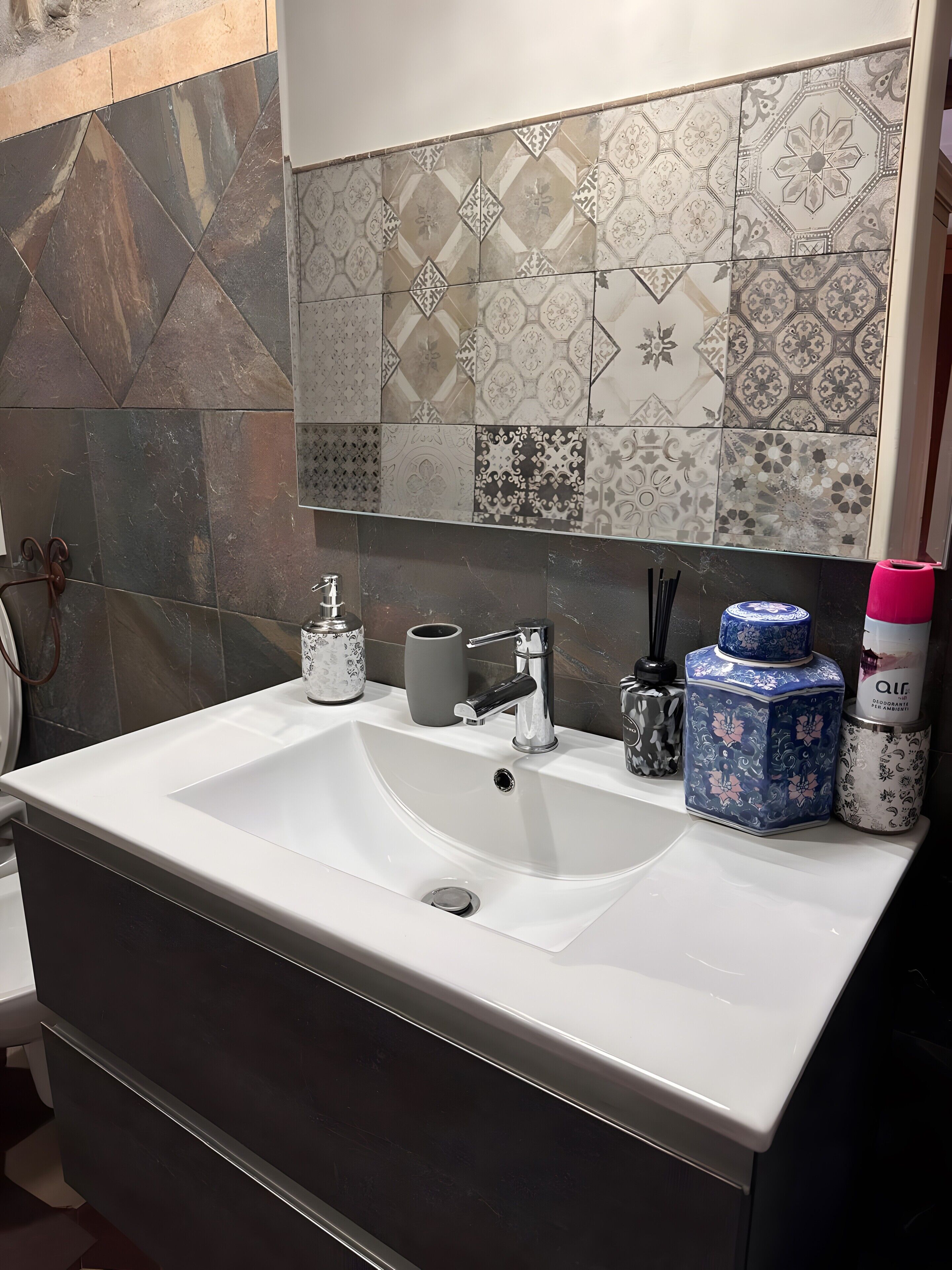 A bathroom with a white sink, a mirror, and a tiled backsplash.