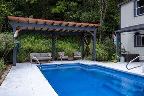 A swimming pool with a wooden deck and lounge chairs. - 5BDR Modern Farm Compound: Pool, Hot Tubs, Trails (Sevierville)