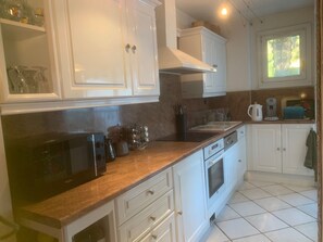 A kitchen with white cabinets, a microwave, a coffee maker, and a toaster. - "Le Soann" 2 bdrms air-conditioning-wifi-sea view (La Ciotat)