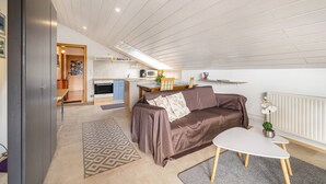 Un salon moderne avec un canapé, une table basse et une cuisine en arrière-plan.