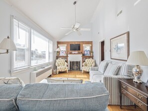 A living room with a sofa, armchairs, a fireplace, a television, and a ceiling fan. - Pet-Friendly Home in Cape May w/ BBQ & Fireplace (Cape May)