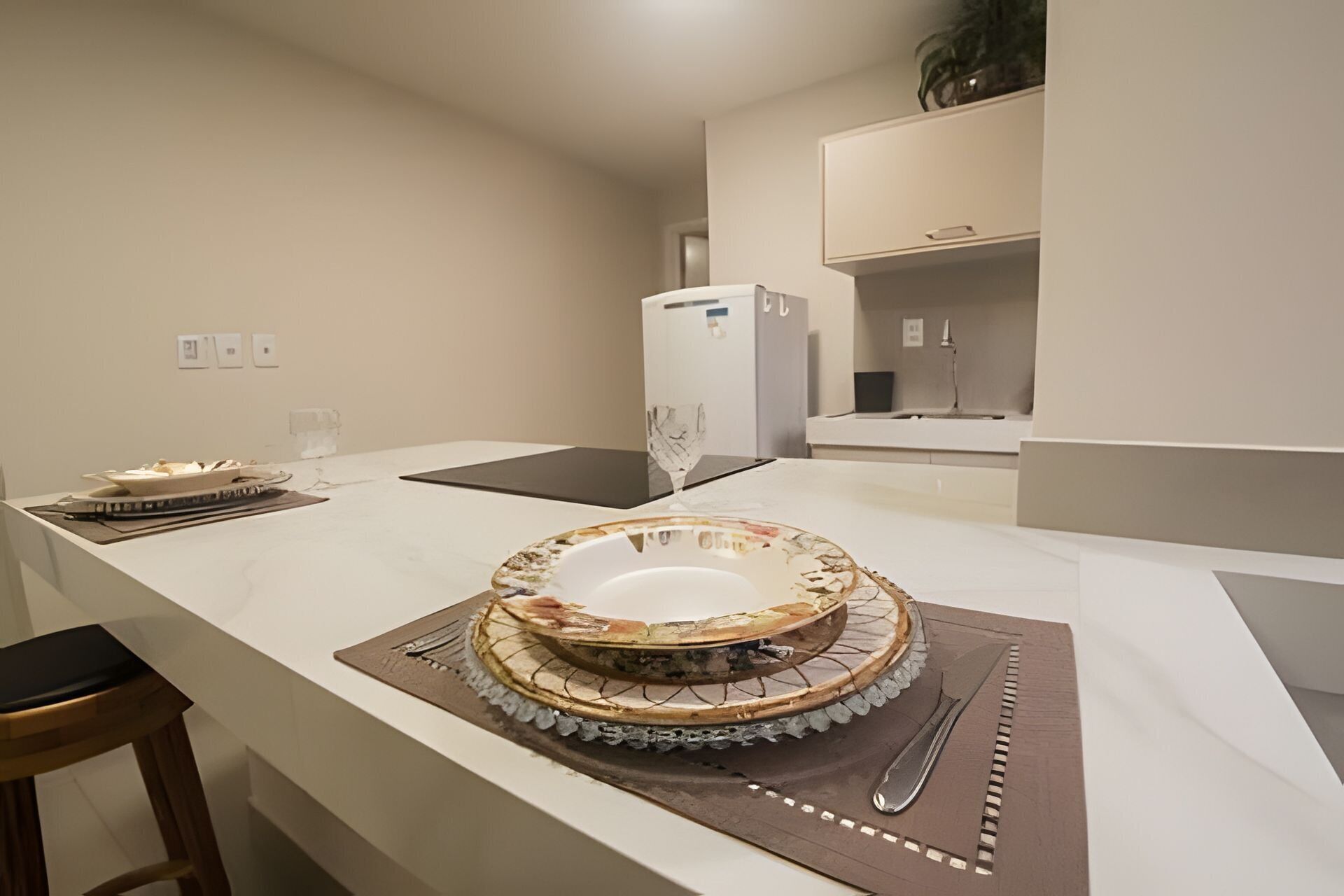 A kitchen with a large island, a refrigerator, and a sink.