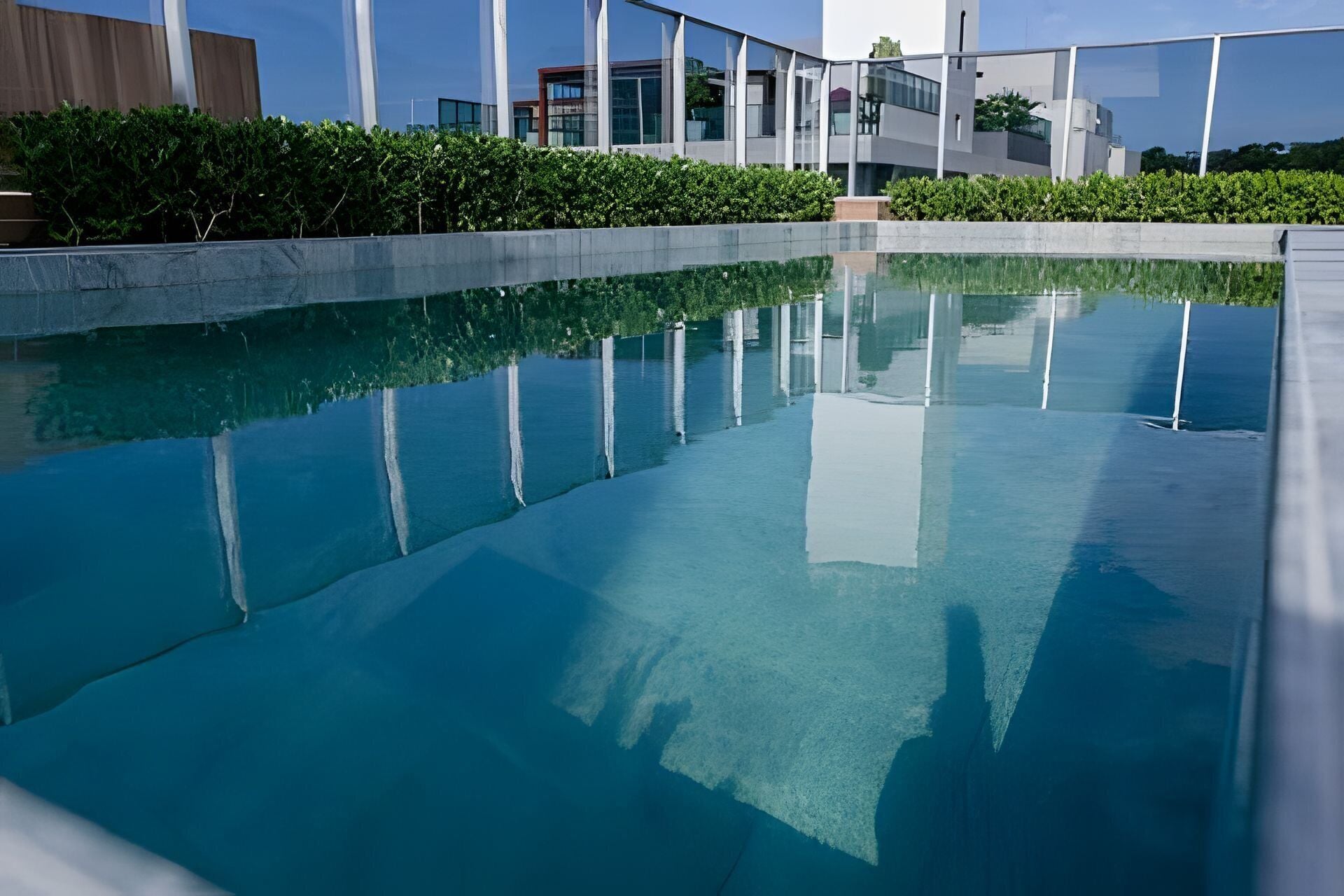 Une piscine aux eaux cristallines, avec un bâtiment moderne en arrière-plan.