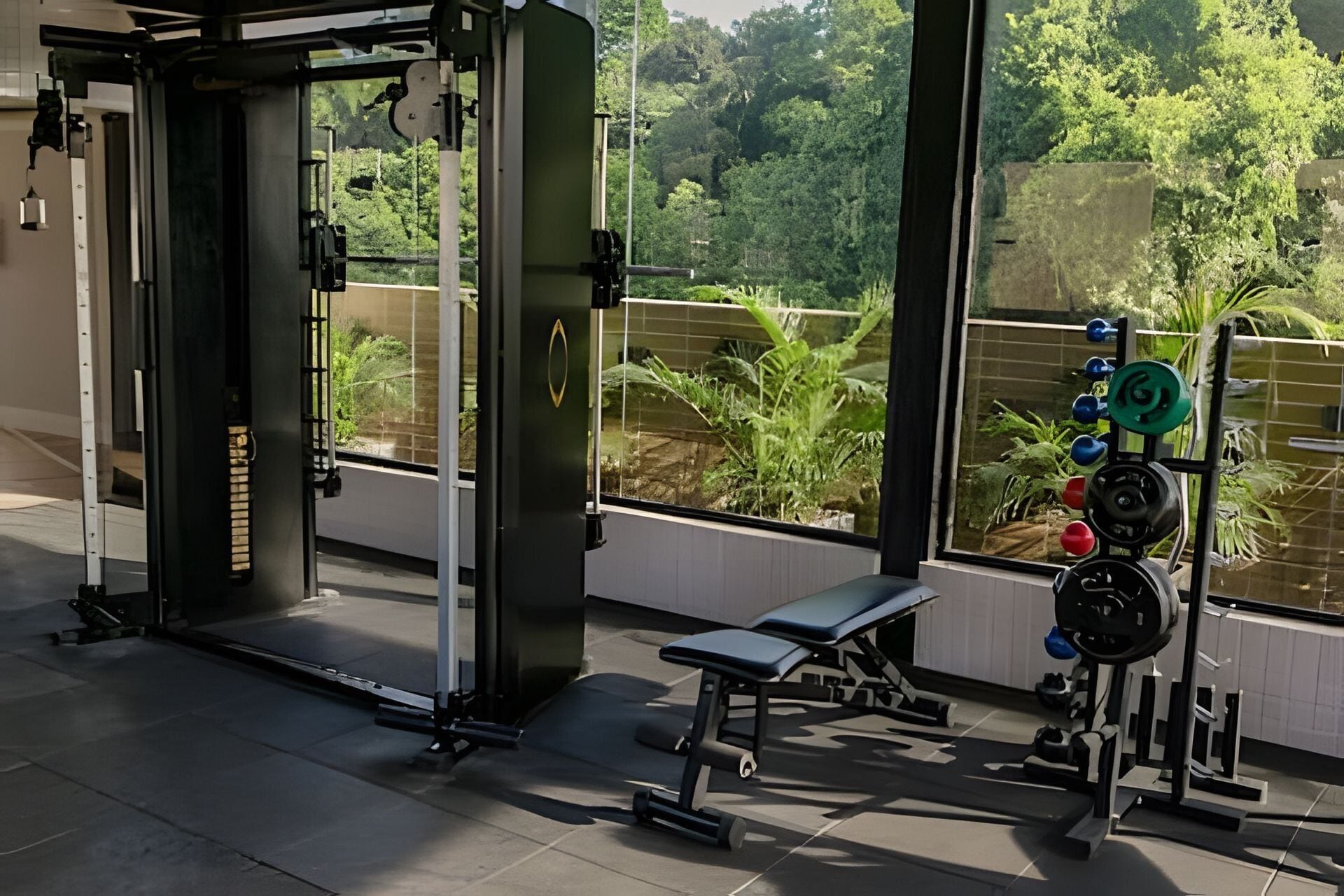 Een sportschool met een rek voor squats, een bank en gewichthefapparatuur.